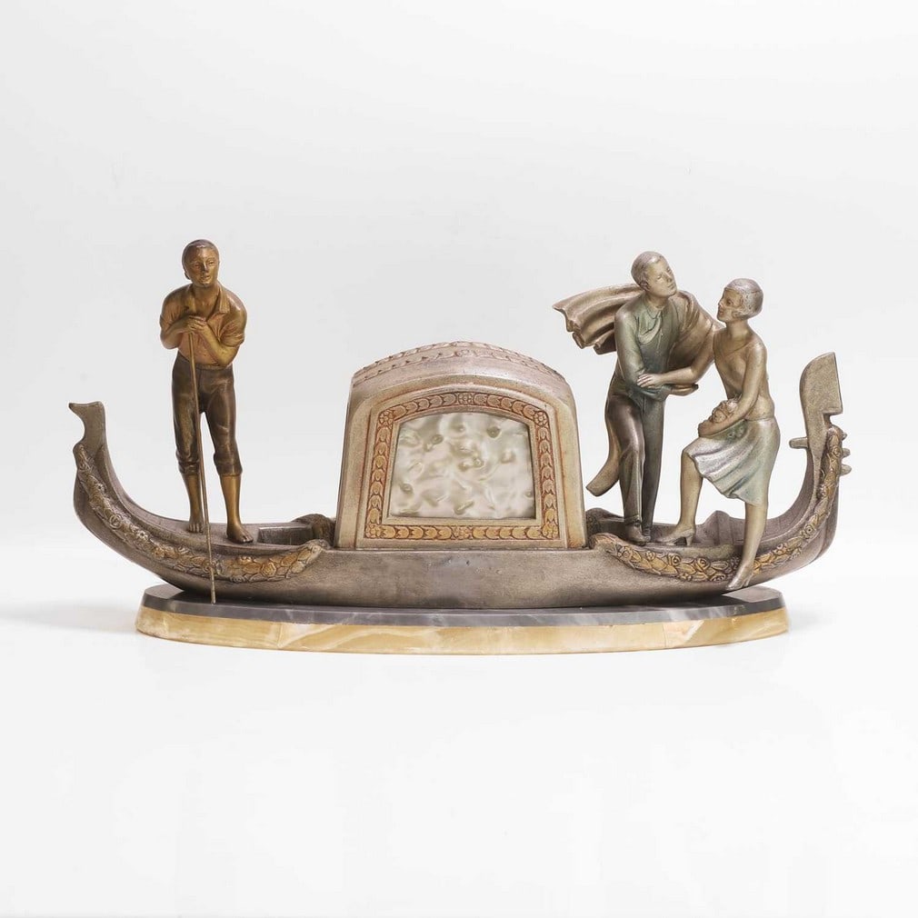 P... Sega (French, 20th century) A cold-painted spelter figure group: P... Sega (French, 20th century) A cold-painted spelter figure group Modelled as a Venetian gondola, with boatman and a couple, the pearlised celluloid panels, mounted with a light (51cm