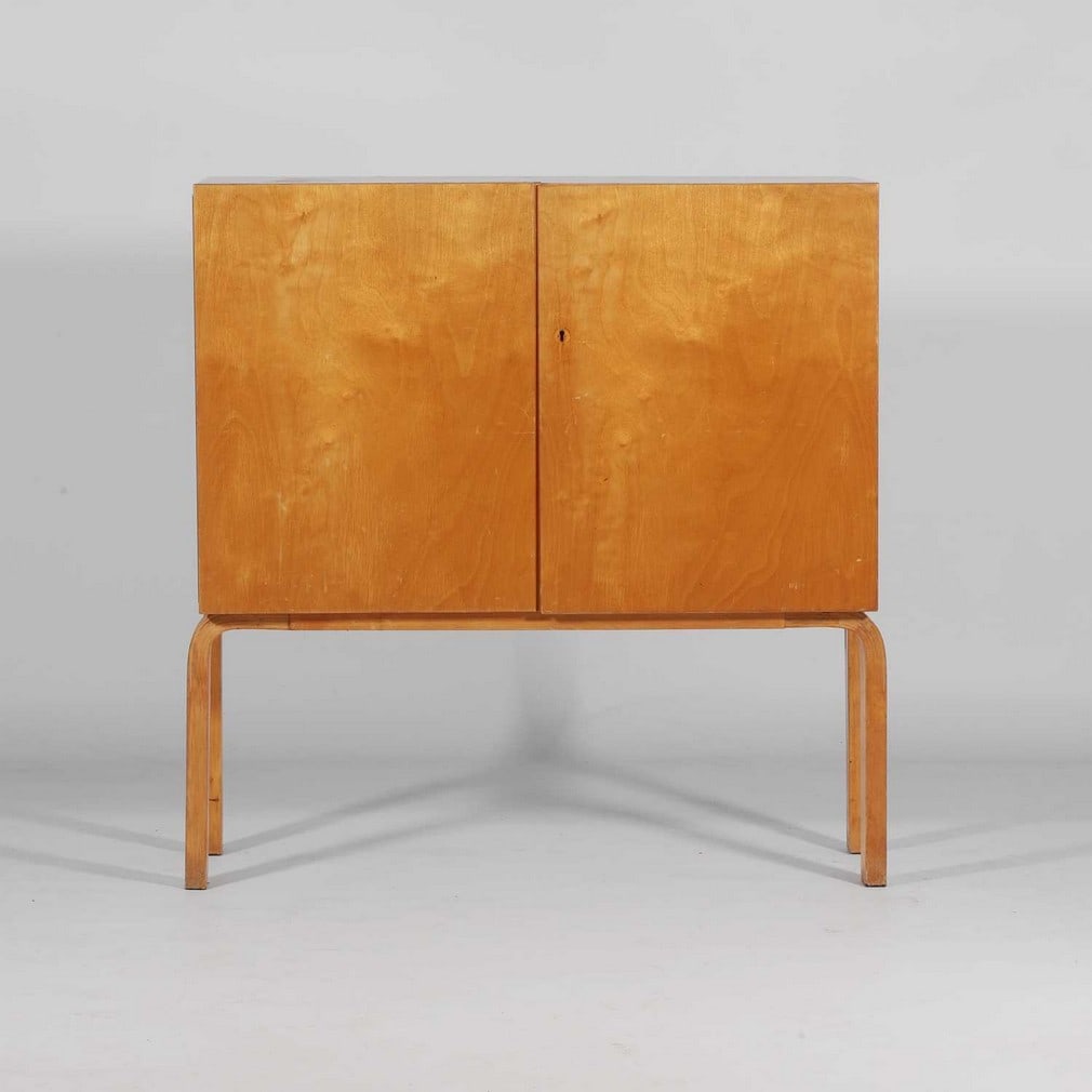 Alvar Aalto (Finnish, 1898-1976) A model '250' cabinet: Alvar Aalto (Finnish, 1898-1976) A model '250' cabinet 1930s, birch plywood with two front doors, opening to reveal five shelves, raised on four legs (95cm wide, 40cm deep, 100cm high)