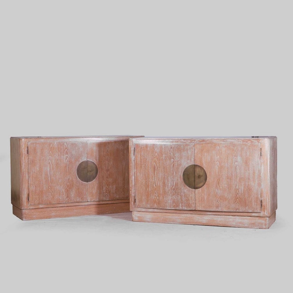 Jacques Adnet (French, 1900-1984) A pair of limed oak cabinets: Jacques Adnet (French, 1900-1984) A pair of limed oak cabinets Each of quadrangular form with rounded uprights resting on a recessed plinth, with two doors, fitted with interior drawers, a circular br