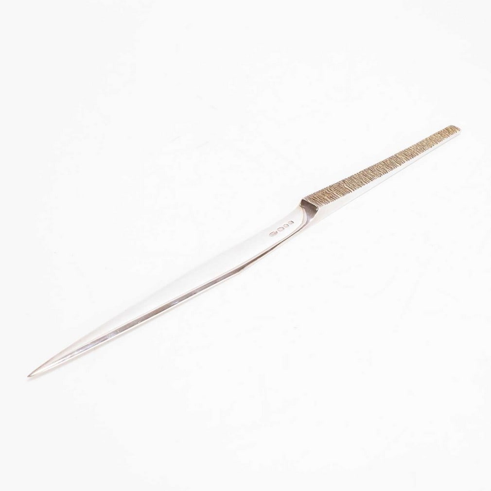 ▲ Stuart Devlin (Australian-British, 1931-2018) A silver and silver-gilt paperknife: ▲ Stuart Devlin (Australian-British, 1931-2018) A silver and silver-gilt paperknife London 1979, of bladed form, with a tapering textured handle, with original box (30cm long, 3.6ozt) (2) Condit