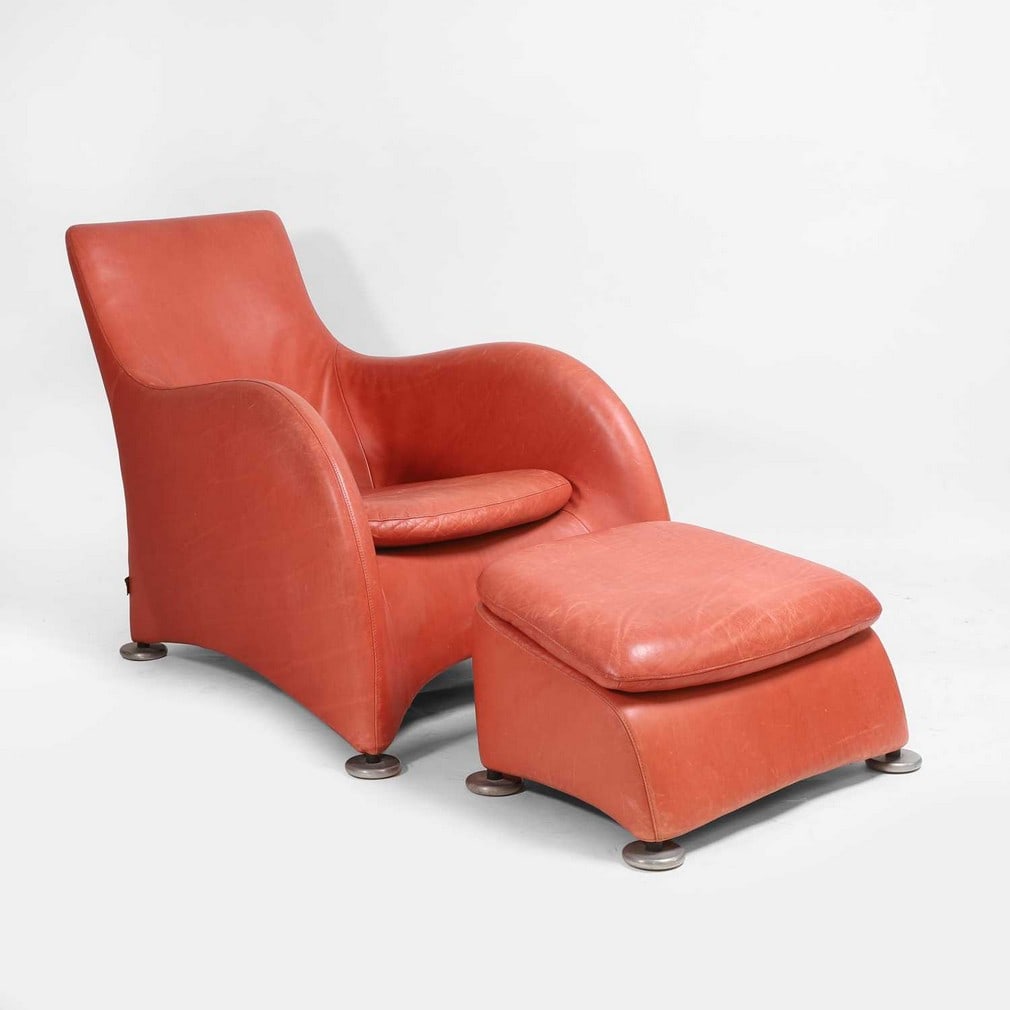 Montis A leather chair and ottoman: Montis A leather chair and ottoman Upholstered in terracotta leather, raised on four brushed aluminium disc feet, with leather manufacturer's label (the chair 66cm wide, 104cm deep, 80cm high,