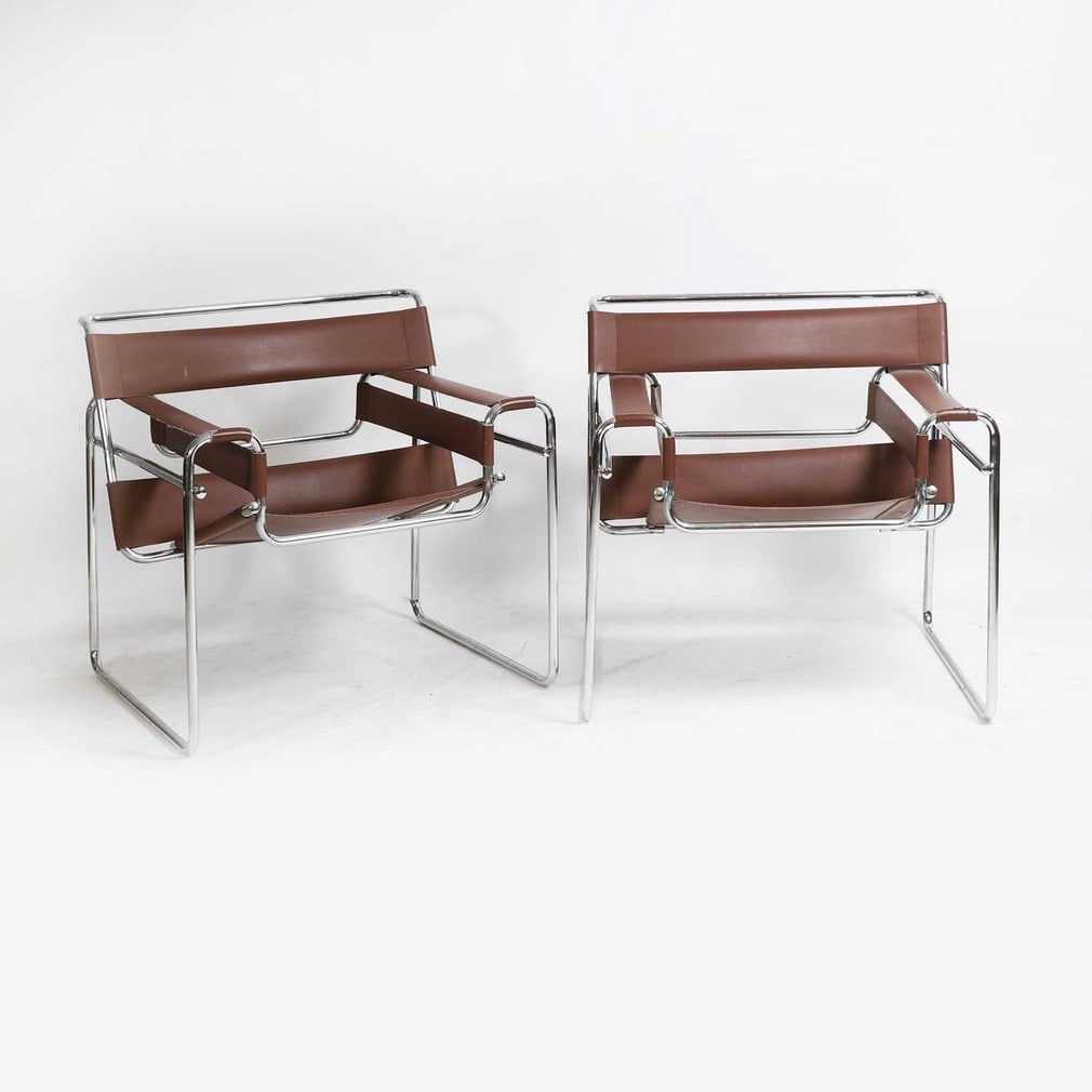 After Marcel Breuer A pair of Wassily chairs: After Marcel Breuer A pair of Wassily chairs Originally designed by Marcel Breuer in 1925, of recent manufacture in Italy, upholstered in brown leather and with a tubular chrome frame, embossed Made i