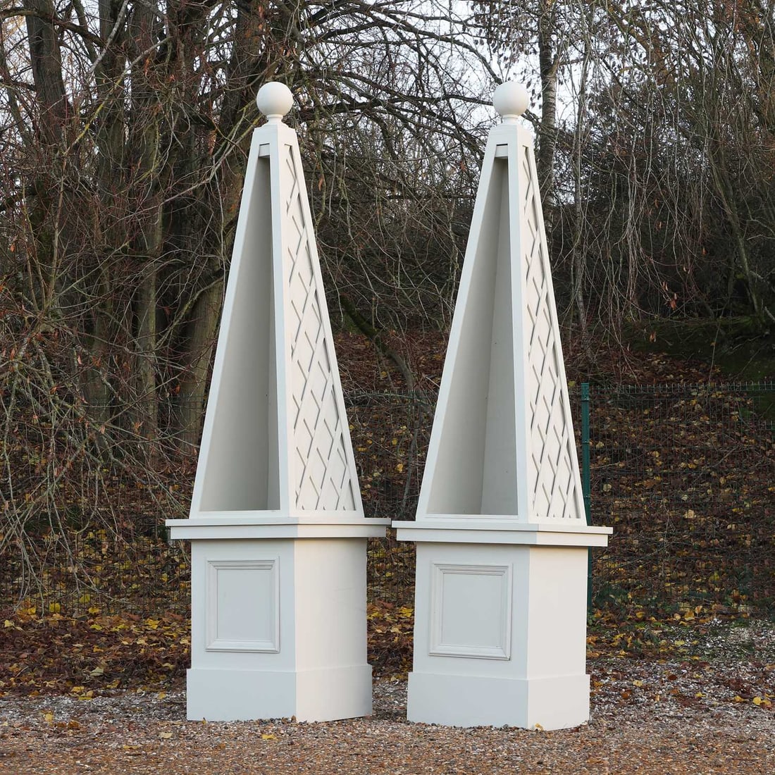 A pair of large modern painted wood obelisk display cases,: A pair of large modern painted wood obelisk display cases, each in two sections, the illuminated tapering tops with ball finials on square bases,90cm wide90cm deep365cm high Provenance: These were de