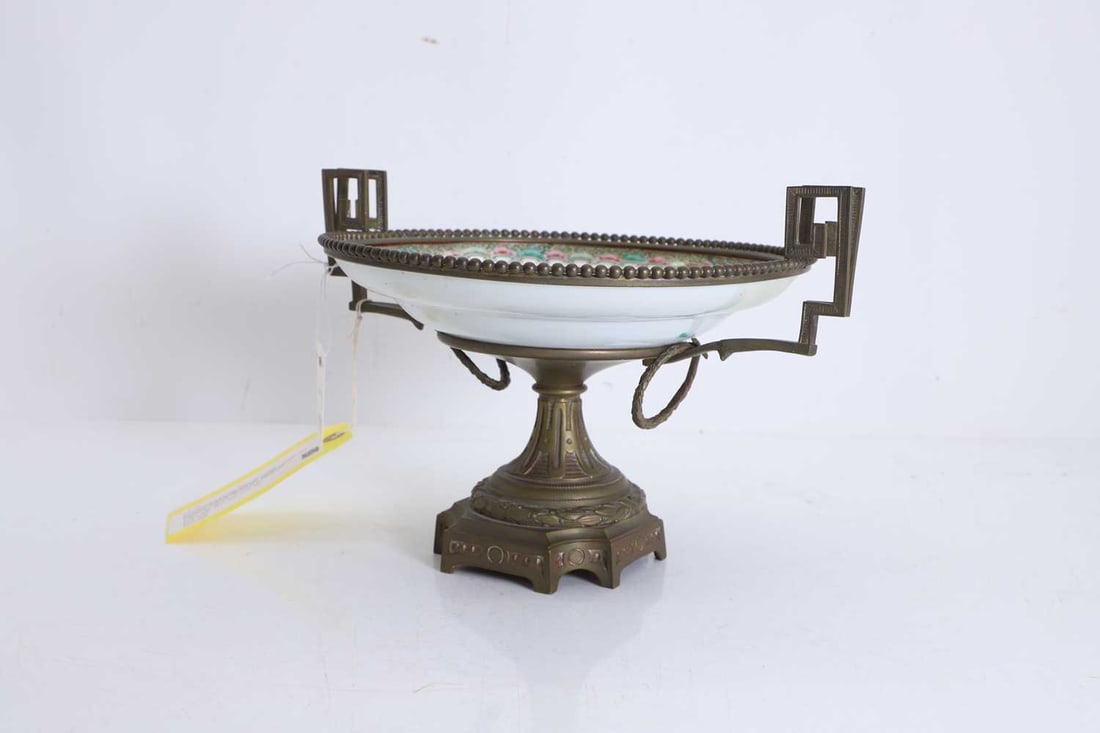 A porcelain and gilt-metal tazza 19th century: A porcelain and gilt-metal tazza 19th century the bowl a Canton famille rose dish, typically enamelled and heightened in gilt with cartouches of interior and landscape scenes, interspesed with