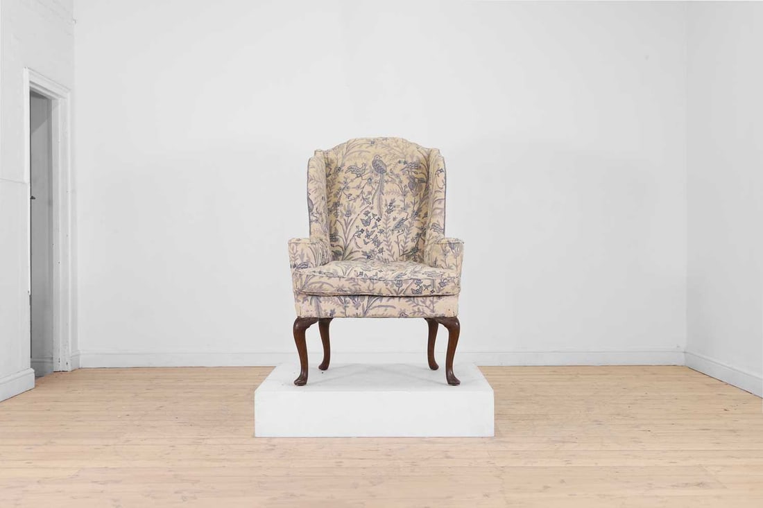 A Queen Anne-style walnut wing armchair 19th century: A Queen Anne-style walnut wing armchair 19th century Upholstered in blue crewel work and raised on cabriole supports terminating in pointed pad feet 83cm wide, 87cm deep, 121cm highProvenance: T