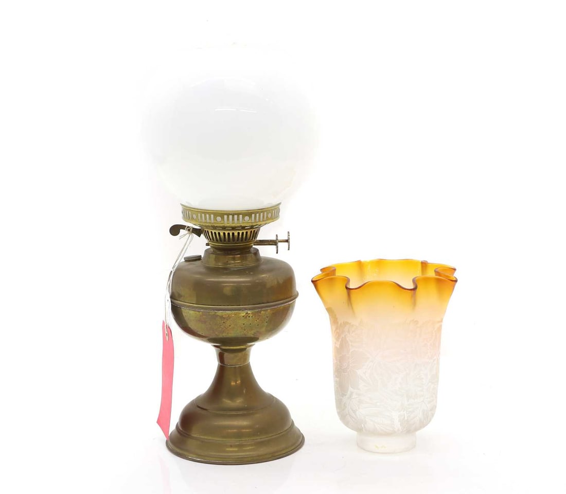 A brass oil lamp, 20th century: A brass oil lamp, 20th century With a circular white glass shade, another orange to clar ombre etched shade Oil lamp, 42cm high; Shade, 19.5cm high Condition Report: Opaline - with