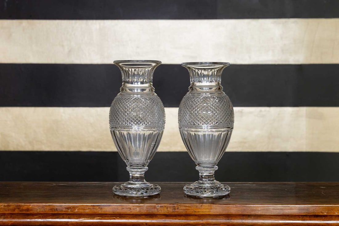 A near pair of Baccarat ‘Edwige’ cut-glass vases Circa 1950, French: A near pair of Baccarat ‘Edwige’ cut-glass vases Circa 1950, French Each with a diamond-cut body, acid-etched marks 16cm diameter, 36cm high 2 Provenance: Previously offered within