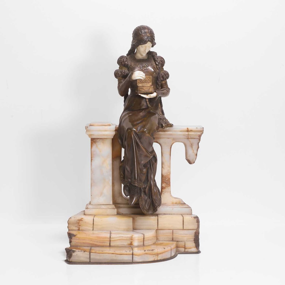 Dominique Alonzo (French, fl.1910-1930) 'The Jewel Box': Dominique Alonzo (French, fl.1910-1930) 'The Jewel Box' A gilt and patinated bronze and ivory figure, modelled as a medieval female opening a jewel box, seated on an onyx balustrade with steps to the