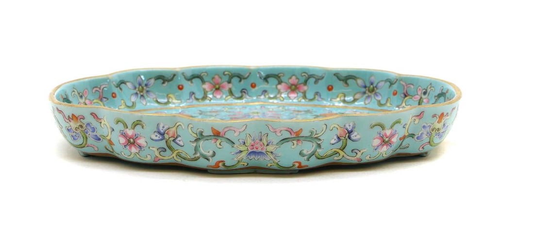 A Chinese famille rose porcelain dish 20th century: A Chinese famille rose porcelain dish 20th century of lobed form, enamelled with melons among scrolling flowers against a blue ground, a six-character Jiaqing mark to base, 15.5cm longCondition