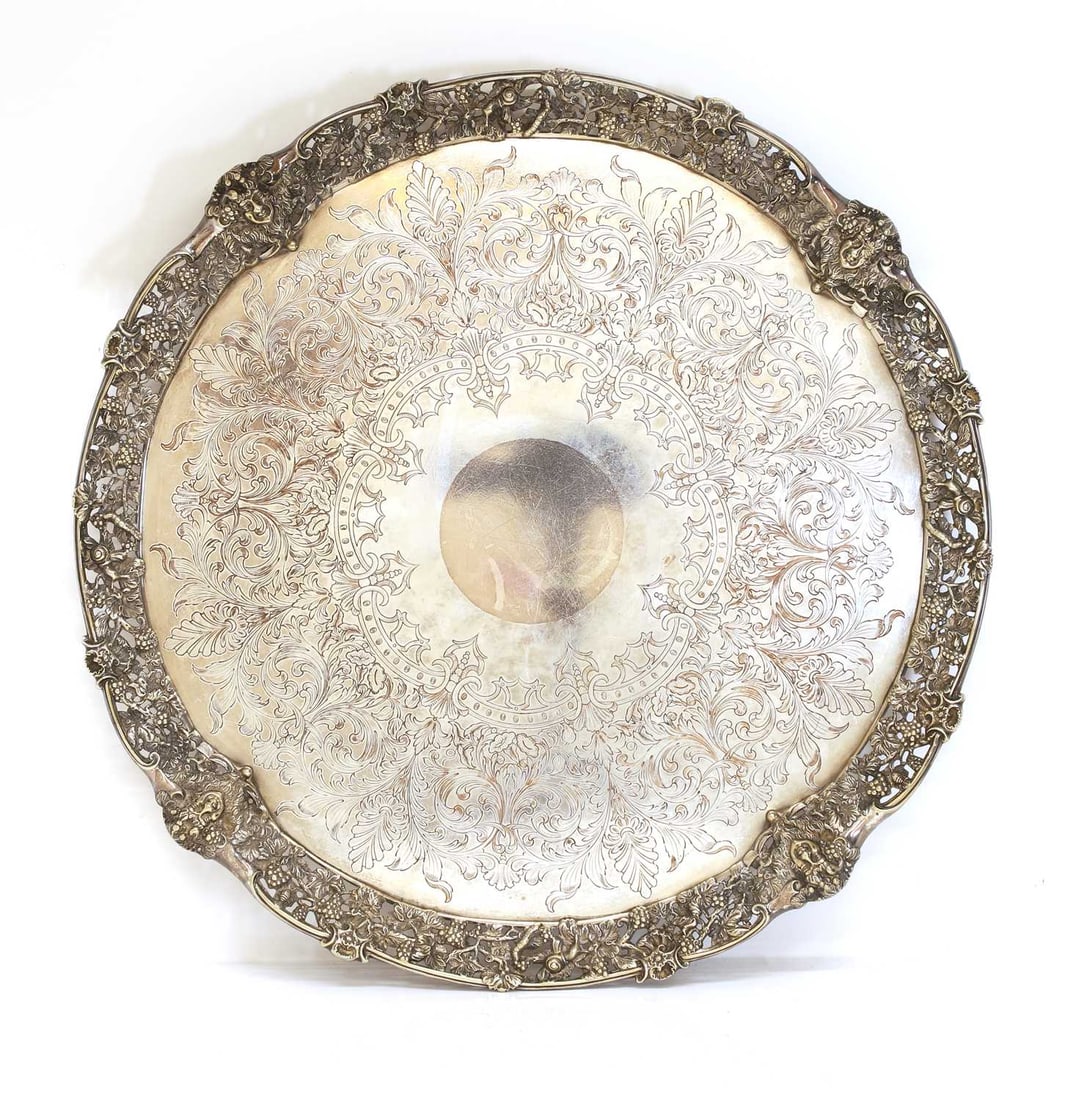 A silver-plated salver, Victorian,: A silver-plated salver, Victorian, of circular form, engraved, with a pierced cast border of vines and Bacchus masks 57cm diameter Condition Report: Some wear and rubbing.
