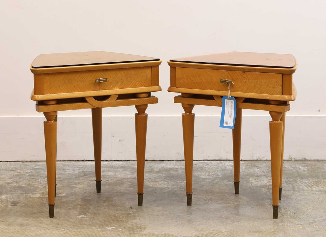 A pair of bedside tables, Circa 1950s, French,: A pair of bedside tables, Circa 1950s, French, with peach mirrored tops, the cylindrical tapering legs with brass caps,with bow shaped handles, with label to the interior of the drawer 'AMEUBLEMENT M