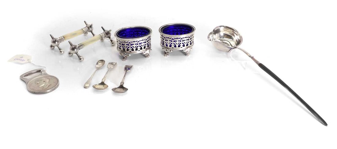 A Christofle bottle opener and a pair of salts,: A Christofle bottle opener and a pair of salts, The salts with pierced decoration, and blue glass liners, together with a toddy ladle with a coin to the dish of the ladle, and pair of knife rests, wi