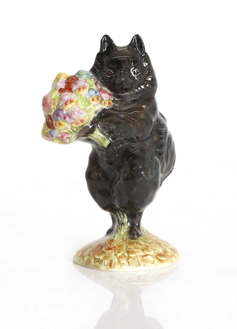 A Beswick pottery figure: A Beswick pottery figure 'Duchess with Flowers', modelled as a black cat standing on its hind legs with a bouquet of flowers, the base with painted and stamped marks 9.6cm highCondition Report: Someo