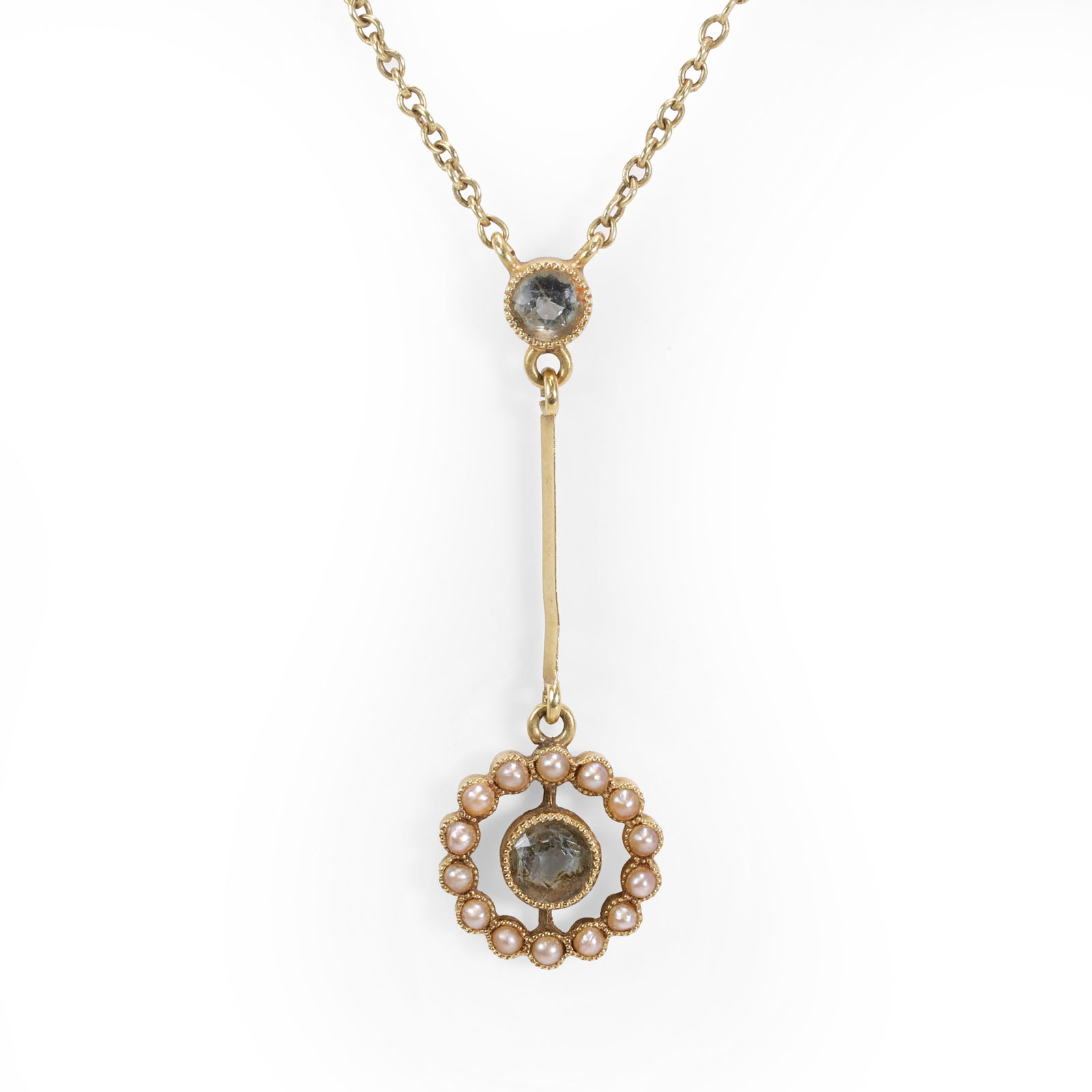 An Edwardian aquamarine and split pearl lavalier necklace,: An Edwardian aquamarine and split pearl lavalier necklace, with a round cut aquamarine, millegrain set and suspending an articulated knife edge bar, to a round cut aquamarine surrounded by a halo of s