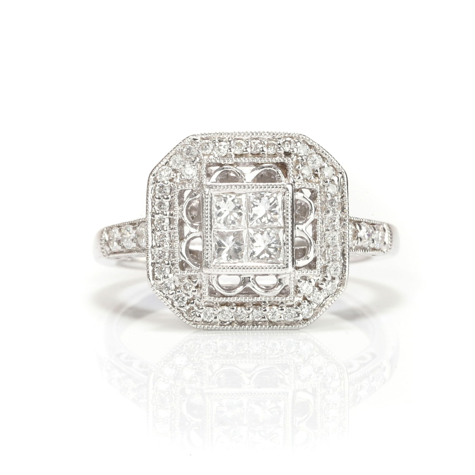 An 18ct white gold diamond ring,: An 18ct white gold diamond ring, centred by a square cluster of princess cut diamonds, to a pierced millegrain surround set with round brilliant cut diamonds, into shoulders each with a short line of