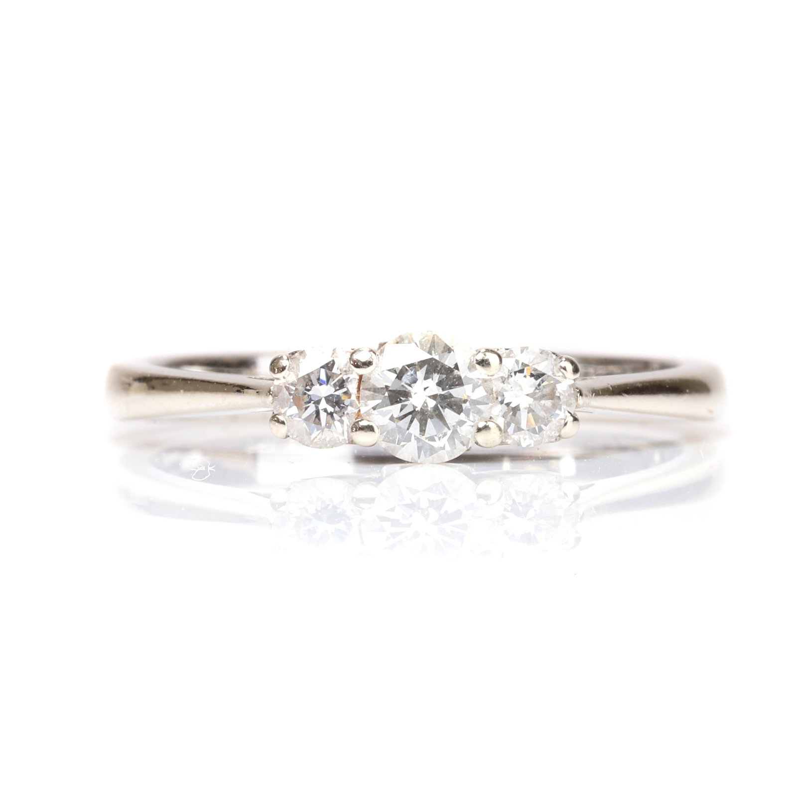 An 18ct gold diamond three stone ring,: An 18ct gold diamond three stone ring, claw set with graduated round brilliant cut diamonds, the underbezel with pierced hearts and a letter 'D' to each side, into tapered shoulders and a 'D' profile