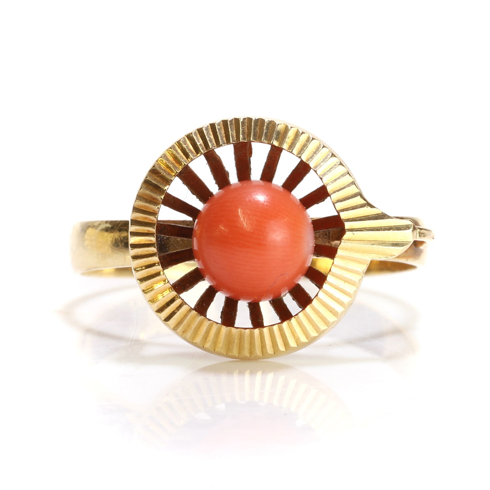 A Portuguese gold red coral ring,: A Portuguese gold red coral ring, centered by a spherical red coral, peg set to a pierced concave mount to a surround with radial engraving, to asymmetric shoulders, one with a wire scroll, the other