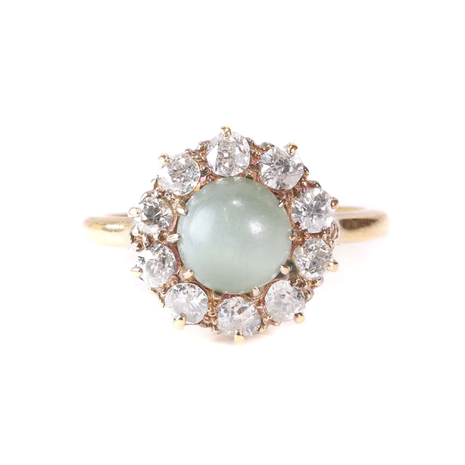 A cat's eye gemstone and diamond cluster ring,: A cat's eye gemstone and diamond cluster ring, claw set with a round cat's eye cabochon to the centre, likely a cat's eye quartz, to a surround of old cut diamonds, into a 'D' profile shank, marked 18
