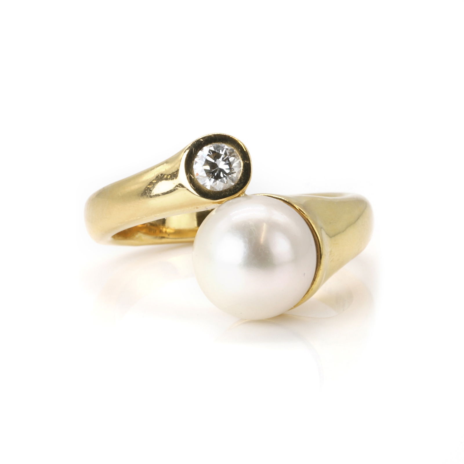 A cultured pearl and diamond ring,: A cultured pearl and diamond ring, of crossover design, set with a cultured pearl and a round brilliant cut diamond, pearl untested, to a wraparound tapering hoop, stamped 18K 750, numbered 51.40 (Pea