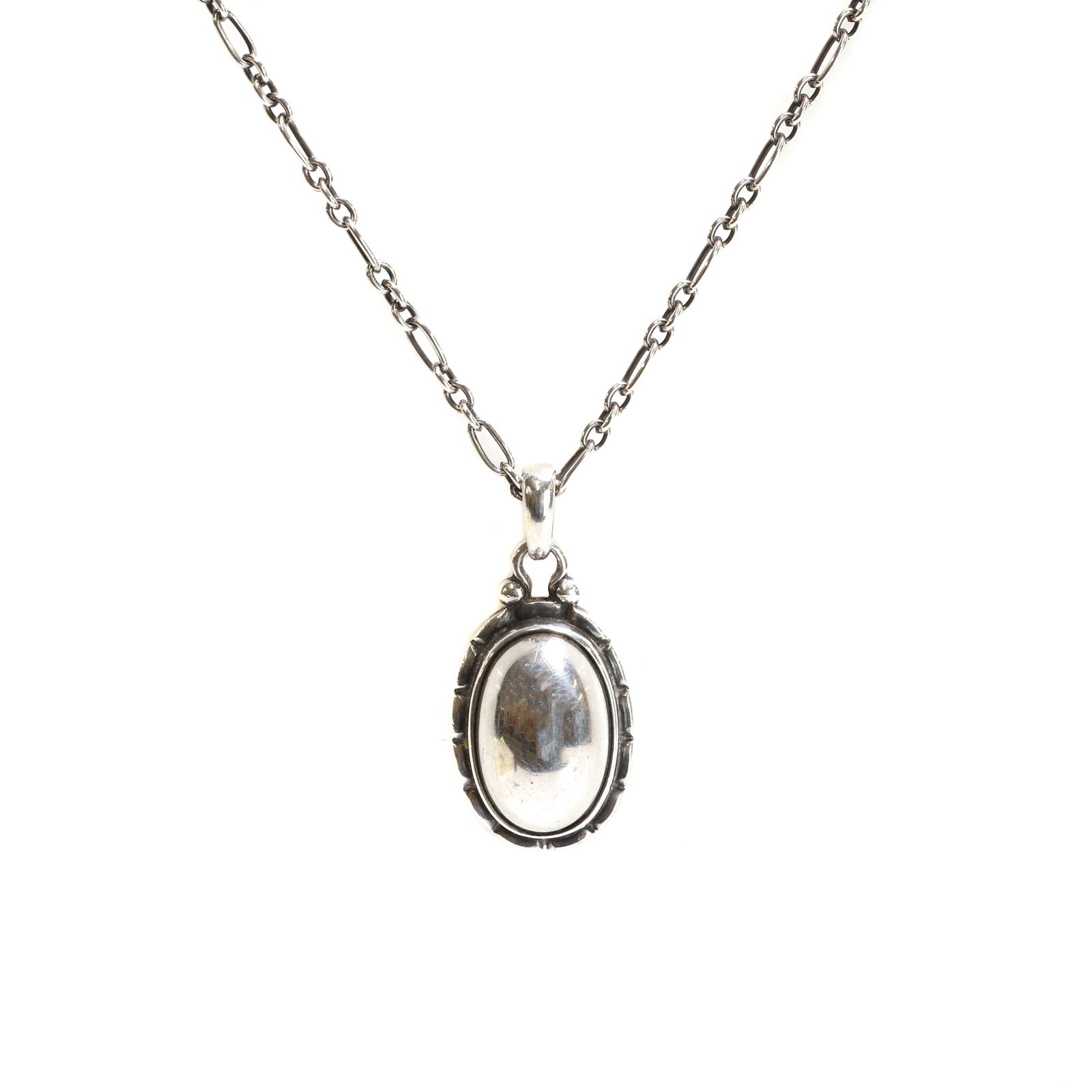 Georg Jensen, a silver pendant of the year 2001,: Georg Jensen, a silver pendant of the year 2001, with a domed oval centre, to an incised surround, to a tapered bale, suspended by a cable link chain with a bolt ring clasp, maker's mark for Georg Jen