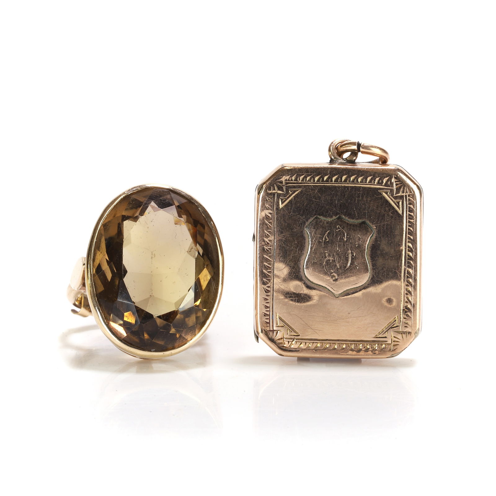 A smoky quartz ring and an antique locket pendant,: A smoky quartz ring and an antique locket pendant, the smoky quartz ring bezel set with an oval cut smoky quartz, to shoulders with applied detail into a 'D' profile shank, stamped 9ct, tested as appr