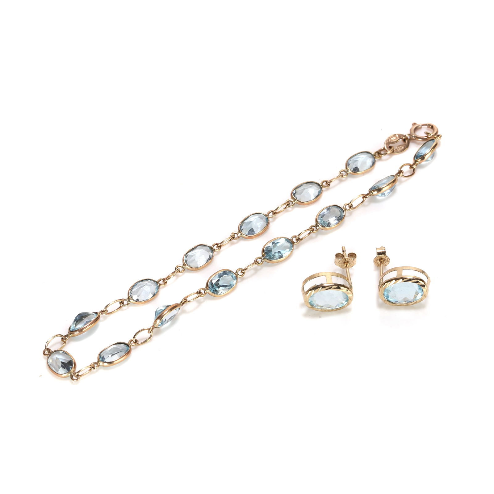 A 9ct gold blue topaz line bracelet and a pair of topaz stud earrings,: A 9ct gold blue topaz line bracelet and a pair of topaz stud earrings, the bracelet with a line of oval cut blue topaz, each spectacle set and alternating to an oval jump ring, to a bolt ring clasp, h