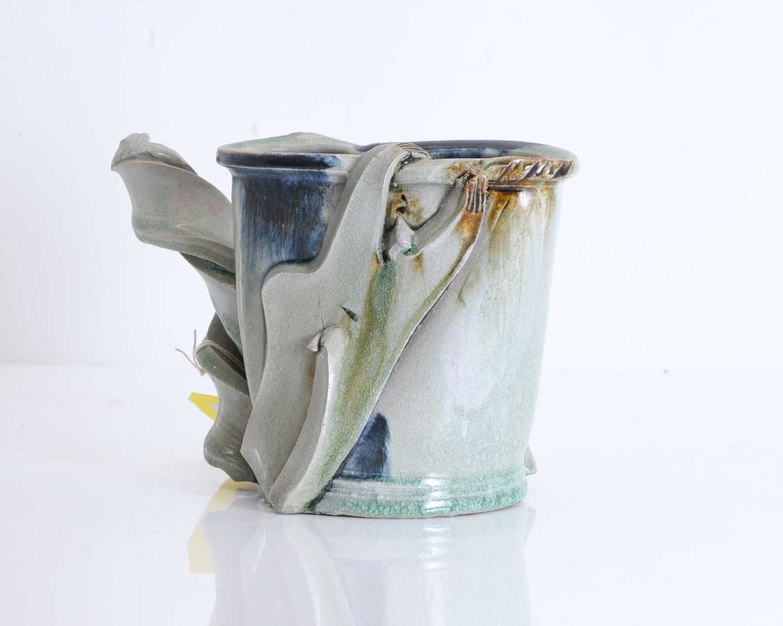 A studio pottery mug, Possibly by Terry Bell-Hughes,: A studio pottery mug, Possibly by Terry Bell-Hughes, of naturalistic form with twisted handle, and stamped mark to the base 22.5cm wide, 15cm high