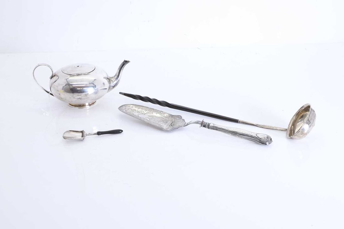 A silver toddy ladle, 20th century: A silver toddy ladle, 20th century inset with George III coin into the bowl, with a turned baleen handle, unmarked, silver plated squat form teapot, together with a silver sugar shovel, by Cocks