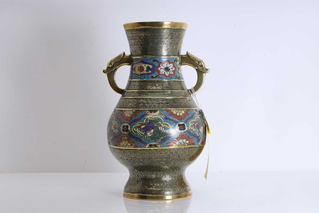 A champleve brass vase, 20th century, Japanese,: A champleve brass vase, 20th century, Japanese, of tapering form flanked by two handles to the neck, with banded decoration of flowers, phoenixes and greek key borders, the handles in the form of