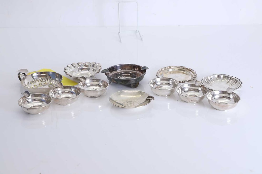 A collection of six silver tastevins,: A collection of six silver tastevins, decorated with a Colombian coin to the main bowl and a small coin handle, tested as silver, two larger examples with coins to the bases, another similar one but