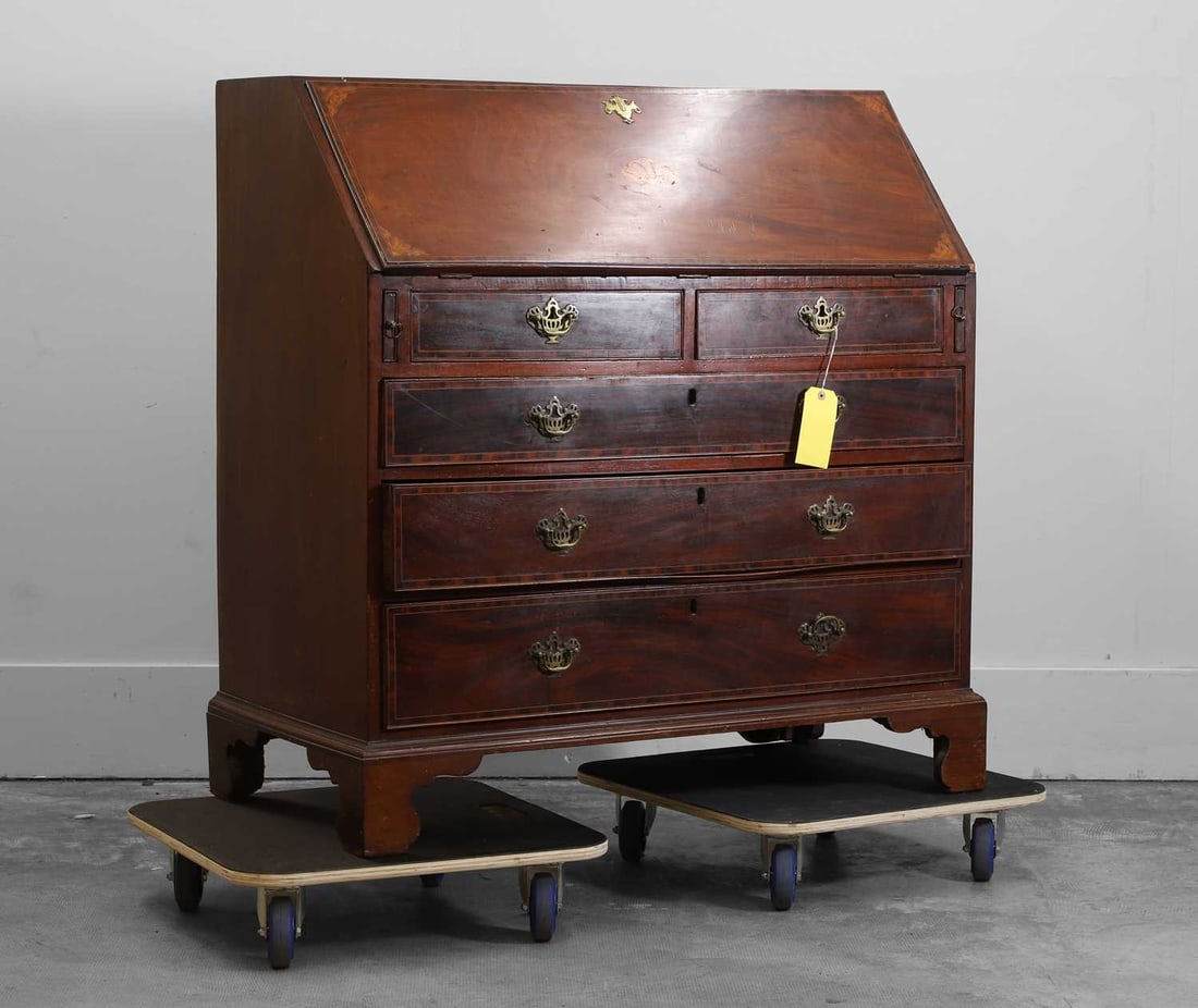 A George III mahogany bureau chest Third quarter 18th century: A George III mahogany bureau chest Third quarter 18th century the sloping fall front with a central shell oval and further line inlay and spandrels, enclosing a fitted interior, above an arrangement