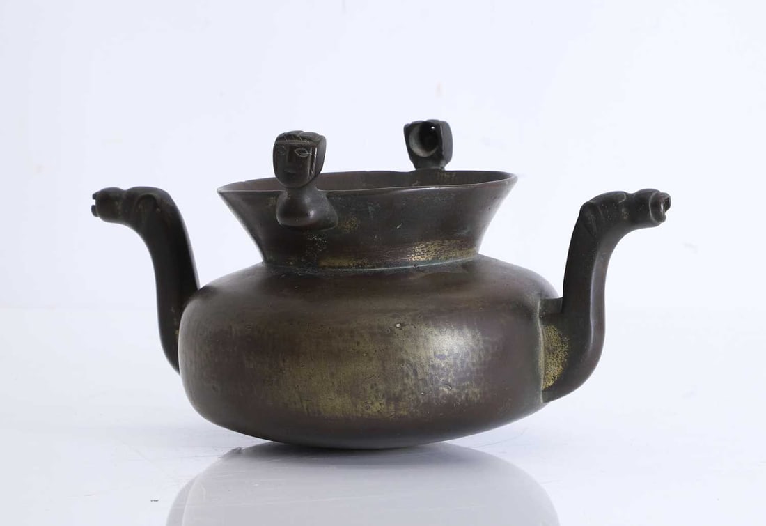 A bronze 'Lavabo' vessel, Possibly 16th century,: A bronze 'Lavabo' vessel, Possibly 16th century, With twin handles shaped as horses and opposing mask supports for a handle 27.5cm wide, 14cm high Condition Report: Handle is missing,