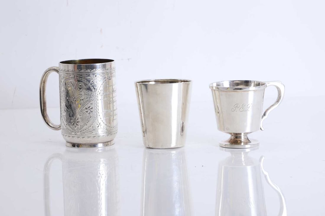 A collection of three silver mugs,: A collection of three silver mugs, including a Christening mug, by Synyer & Beddoes, Birmingham, 1922, monogrammed 'P.E.D', with stepped circular base, cased, a floral engraved mug, by Chawner &a