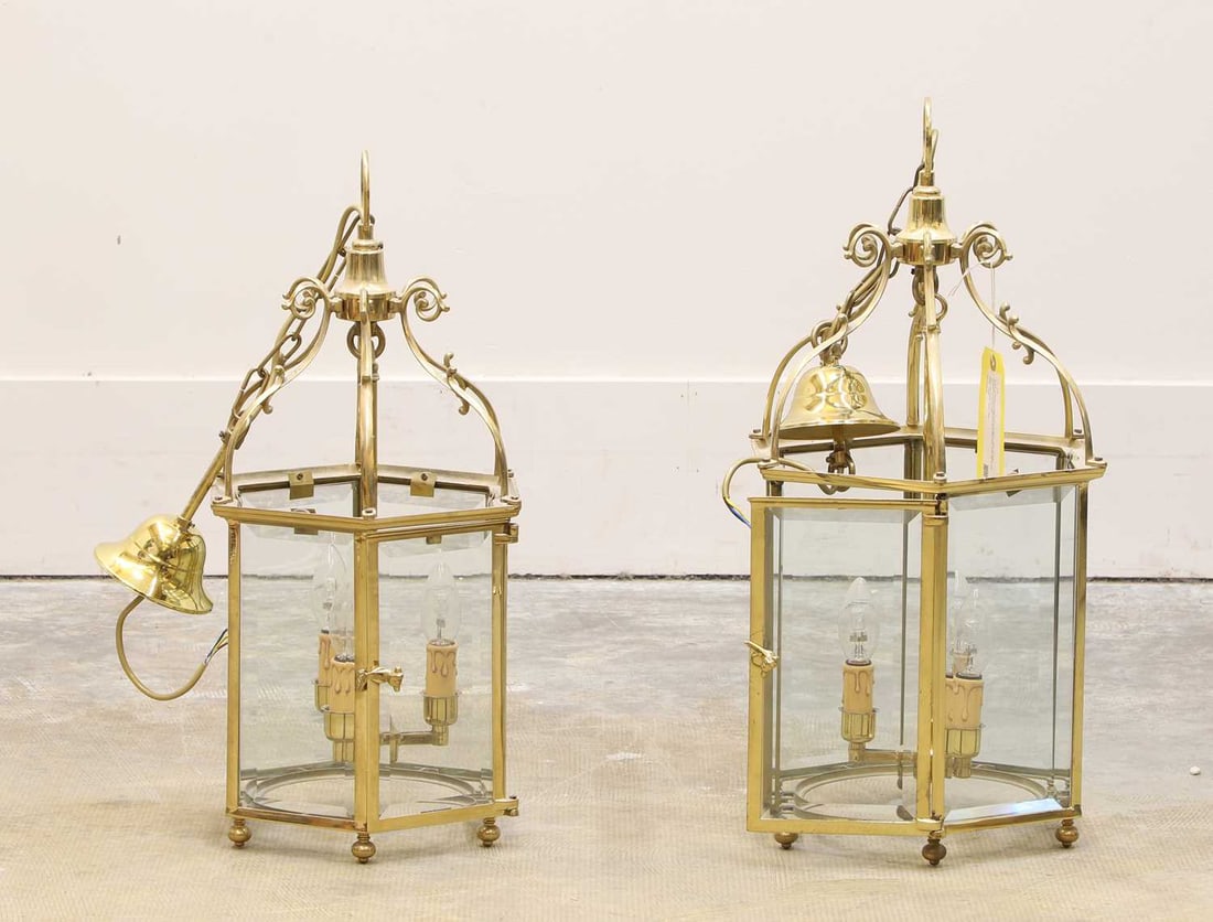 A pair of brass hexagonal hall lanterns, 20th century,: A pair of brass hexagonal hall lanterns, 20th century, each with scrolled supports, and fitted with three lights and becelled glass panels 29cm diameter, 63cm high2Condition Report: Modern, good ove
