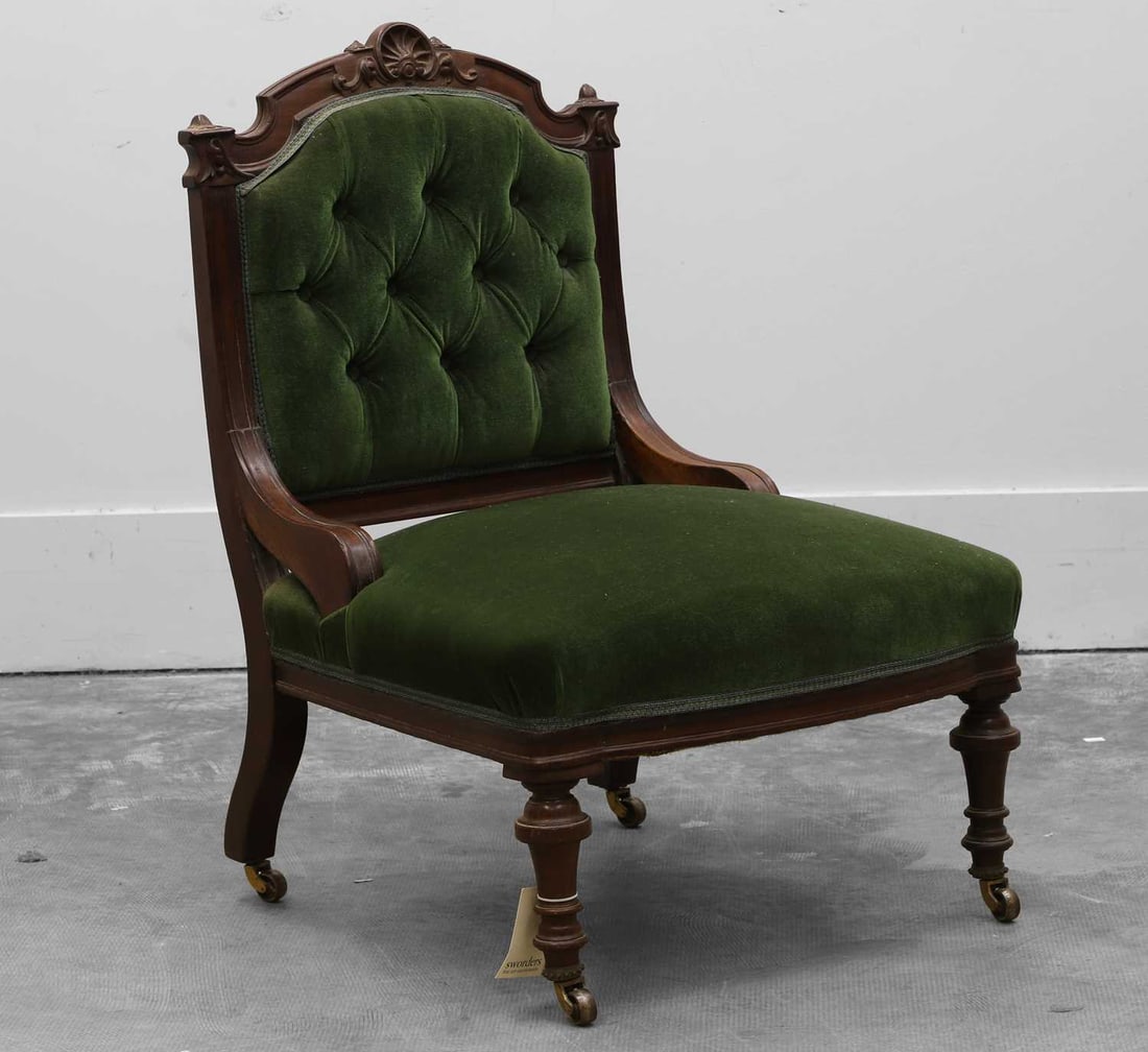 A Victorian walnut nursing chair in the manner of Holland and Sons, Late 19th century,: A Victorian walnut nursing chair in the manner of Holland and Sons, Late 19th century, the moulded frame with carved shell surmount, on tunred supports terminating in beaded castors 64cm wide, 62cm