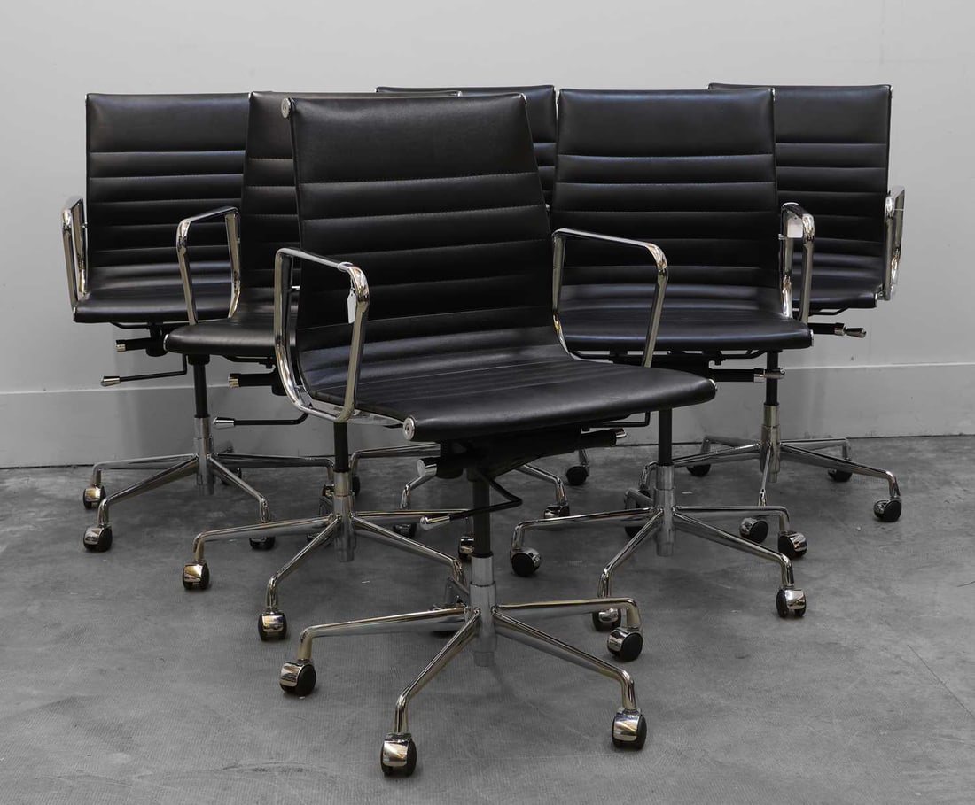 A set of six chrome and leather chairs, Of recent manufacture,: A set of six chrome and leather chairs, Of recent manufacture, in the style of Eames, with chrome arm rests and padded leather seats, sat on five castors with chrome and plastic seat controls, 