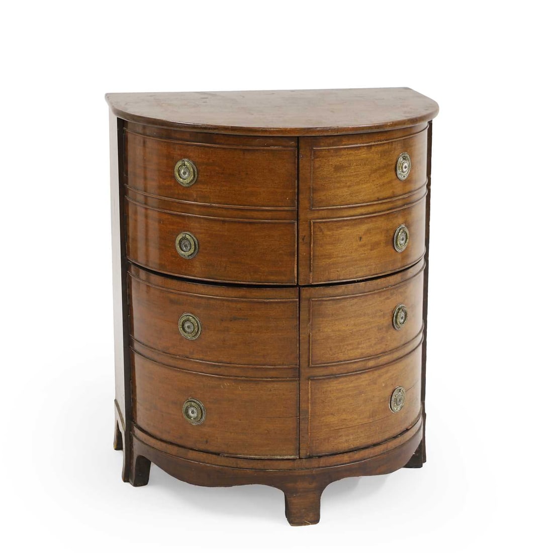 A mahogany bow front night table,: A mahogany bow front night table, c.1820, the barrel front opening into four cupboard drawers, revealing a single shelf interior lined with green baize, 60.5cm wide 46cm deep 72cm high Condition