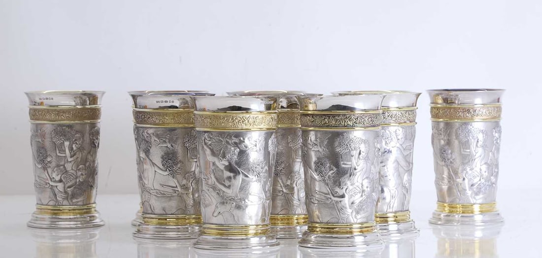 A set of ten silver gilt wine beakers, by Richard Jarvis, London, 2003,: A set of ten silver gilt wine beakers, by Richard Jarvis, London, 2003, each of tapering cylindrical form, with a band of vines and grapes, over a band of bacchanalian figures and animals 14.5cm high