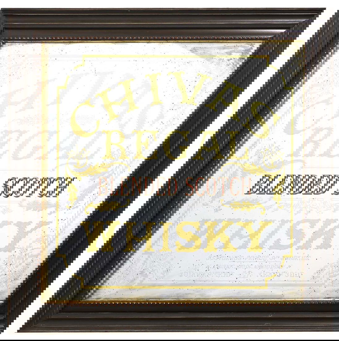 A Chivas Regal scotch whiskey advertising mirror, Early 20th century,: A Chivas Regal scotch whiskey advertising mirror, Early 20th century, gilt and red reverse painted decoration, 'Chivas Regal blended scotch whisky' within a dark moulded wooden frame 124cm wide, 124c