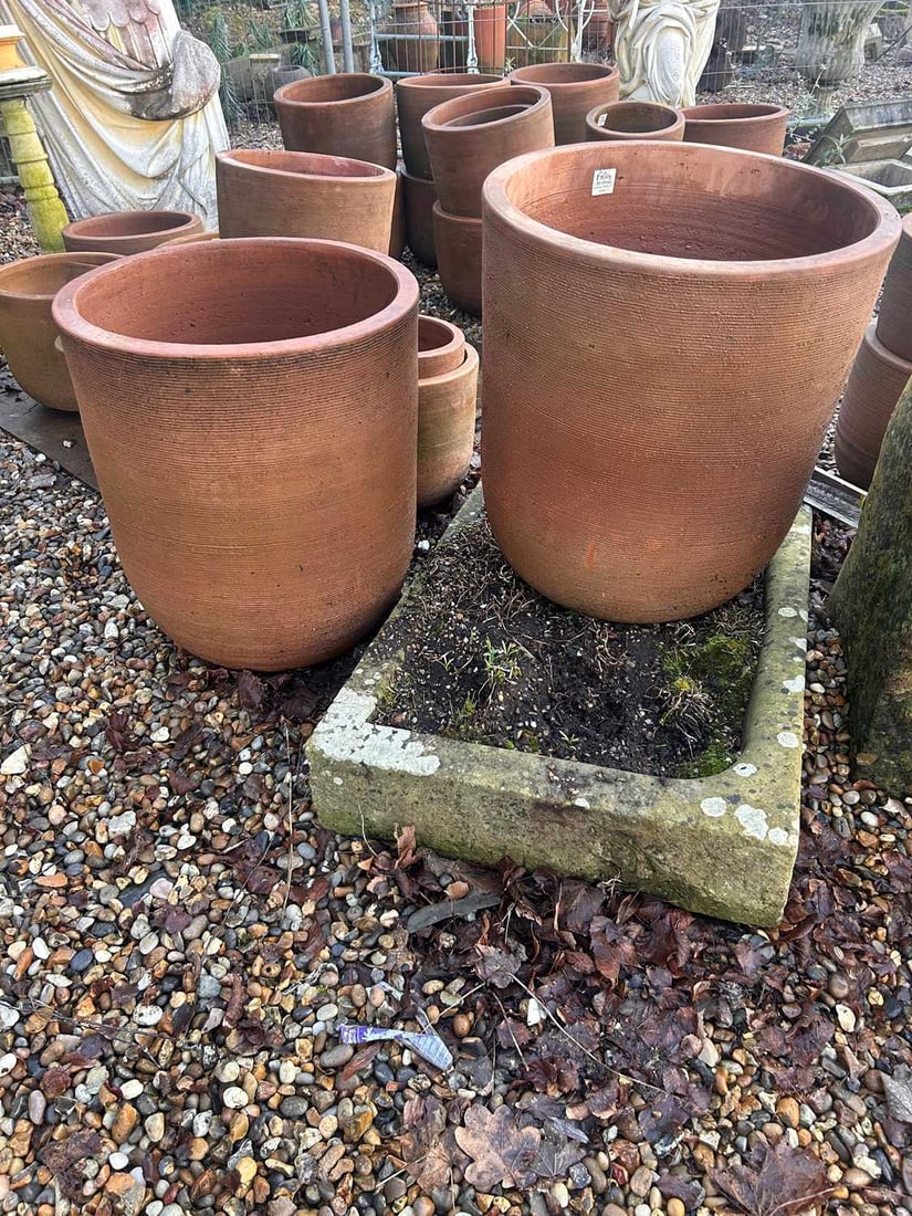 A large pair of terracotta pots, Of modern manufacture,: A large pair of terracotta pots, Of modern manufacture, with grooved design to the side 50.5cm diameter, 59cm high 2 Condition Report: One with a crack to the side, both drilled