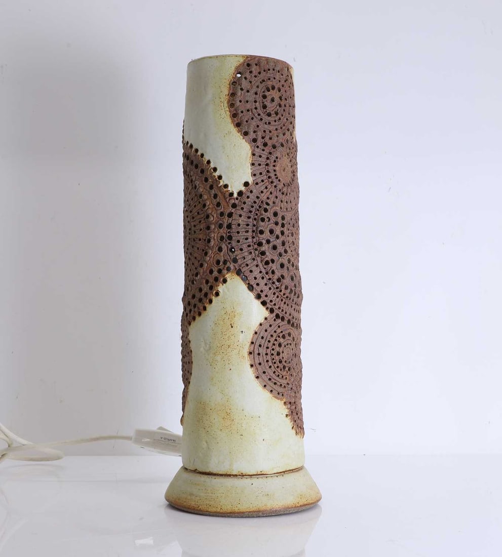 A Bernard Rooke stoneware lampbase, Circa 1974,: A Bernard Rooke stoneware lampbase, Circa 1974, of cylindrical form with a pierced circular motif to the exterior 15cm wide, 48.5cm high Provenance: Certificate provided Condition Report: We