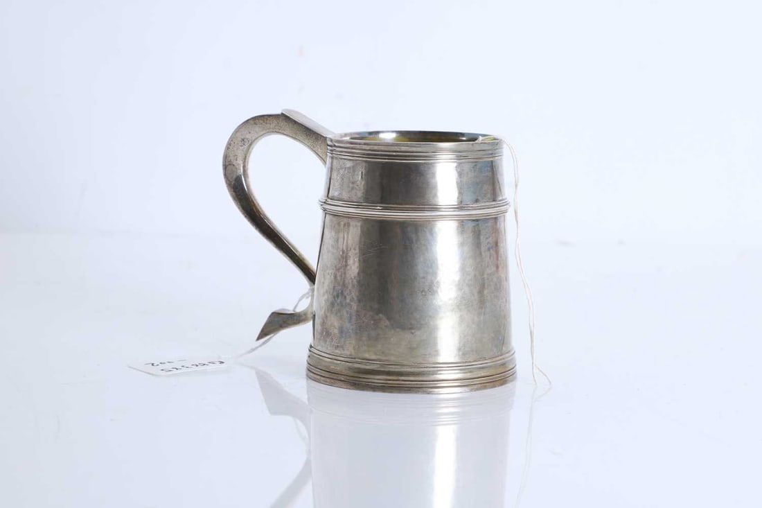 A George III style silver mug, 20th century: A George III style silver mug, 20th century by William Comyns & Sons Ltd, London 1974, of plain cylindrical form with reeded borders to the rim and foot, fitted with a scroll handle terminating