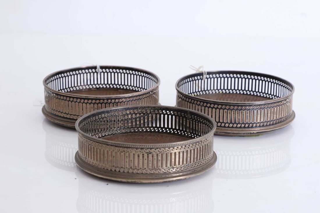 Three silver mounted wine coasters,: Three silver mounted wine coasters, By R Hodd & Son, London, 1979, with pierced design, wooden turned bases The largest, 12.5cm diameter, 4cm high; Total, 11.2ozt 3 Condition Report: A