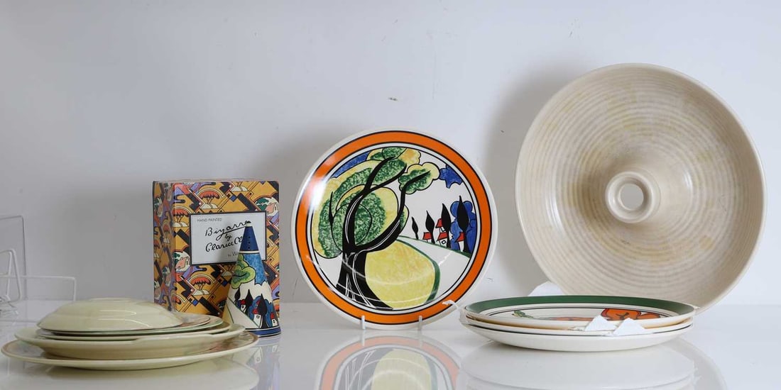 A collection of Clarice Cliff ceramics, Of modern manufacture,: A collection of Clarice Cliff ceramics, Of modern manufacture, to include four cabinet plates from the Big Anne collection, May Avenue, Solitude, Blue Firs, and Orange Erin, all with certificates, a