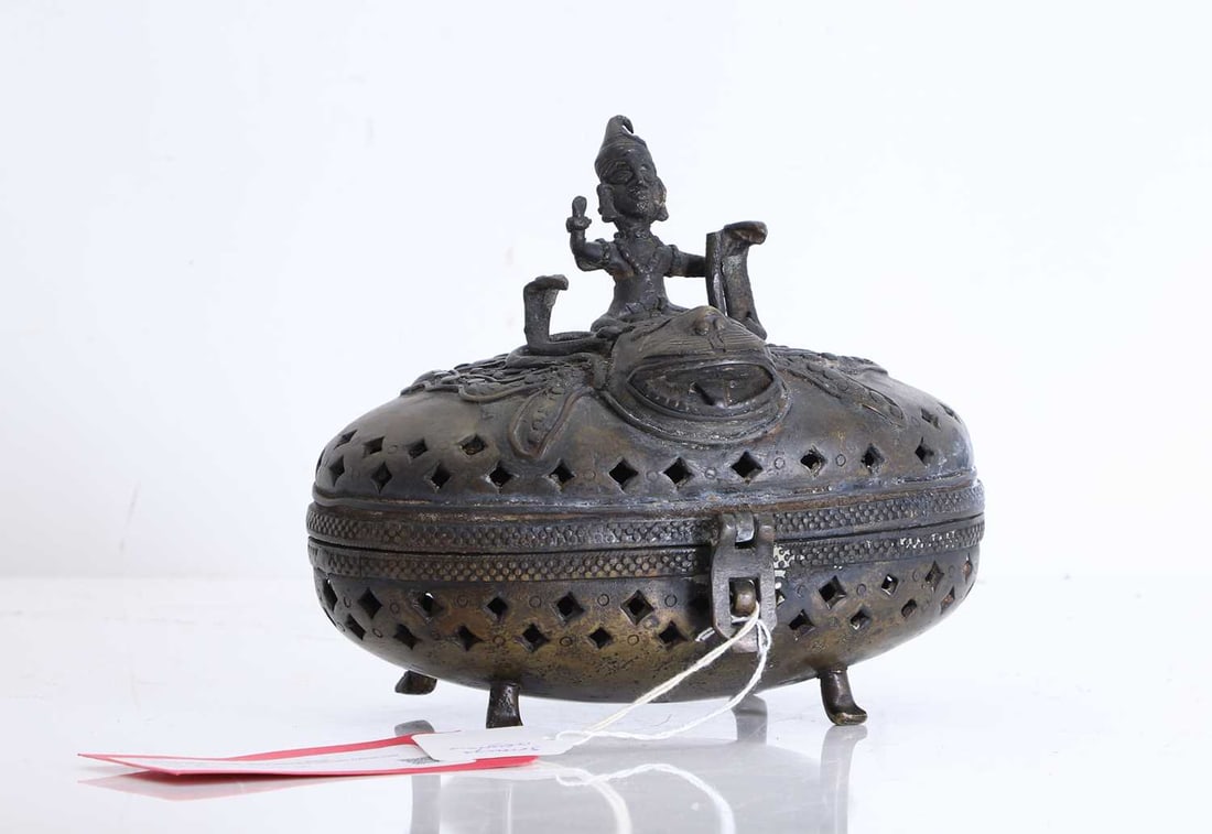 A bronze box and cover, 20th Century, Benin,: A bronze box and cover, 20th Century, Benin, surmounted by a figure riding a leopard with two cobras over pierced sides 22cm wide, 14cm deep, 20cm high2Condition Report: The hinge broken. Tarnishing