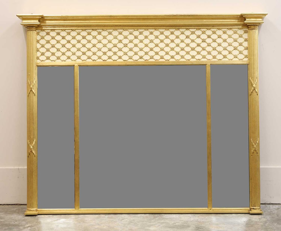A gilt and painted overmantel mirror 20th century: A gilt and painted overmantel mirror 20th century the rectangular frame surmounted by a moulded cornice above a pierced and moulded lattice frieze, flanked by fluted pilasters carved with husk