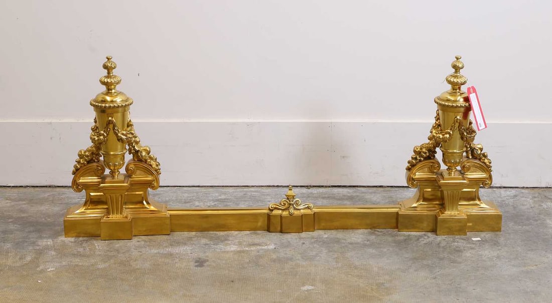 A Louis XV style gilt bronze fender, 20th century,: A Louis XV style gilt bronze fender, 20th century, adjustable, the supports are shaped as urns with fruit swags and shaped finials 112cm wide, 51cm high Condition Report: Fair overall.