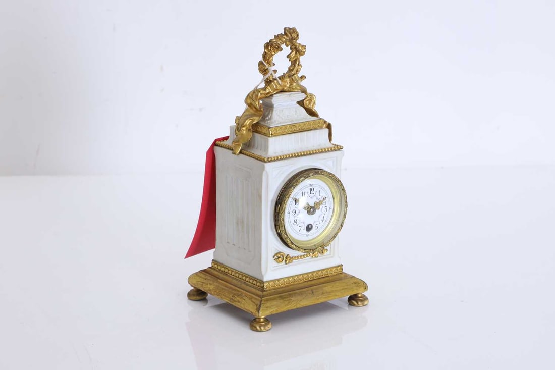 A French bisque and gilt clock, 20th century,: A French bisque and gilt clock, 20th century, with Arabic chapter ring and dial decorated with floral swags, the case surmounted with rose wreath and ribbon swag 11.5cm wide, 12cm deep, 24cm high