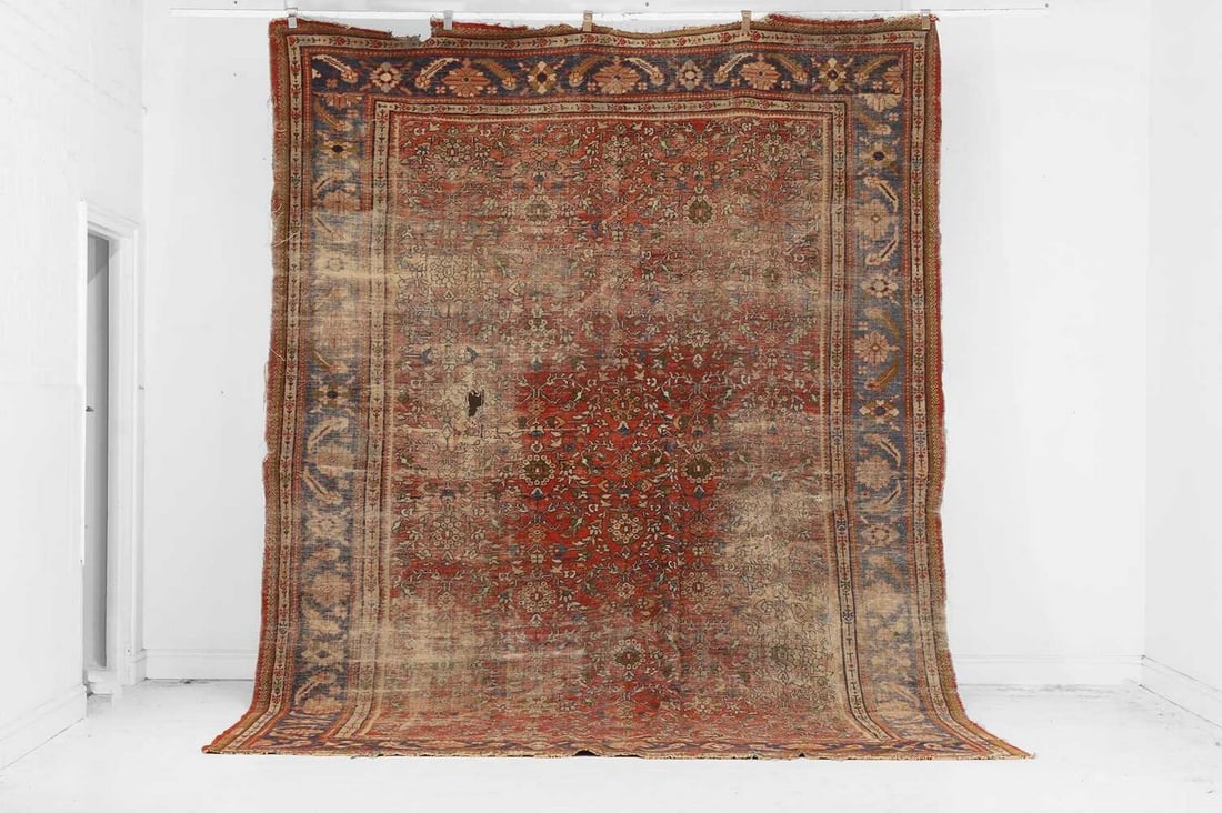 A Persian Mahal wool carpet, early 20th century,: A Persian Mahal wool carpet, early 20th century, woven with repeating Herati motifs to a red ground, distressed (370 x 246cm) Provenance: The Richard Collins Collection. Condition Report: Worn, faded