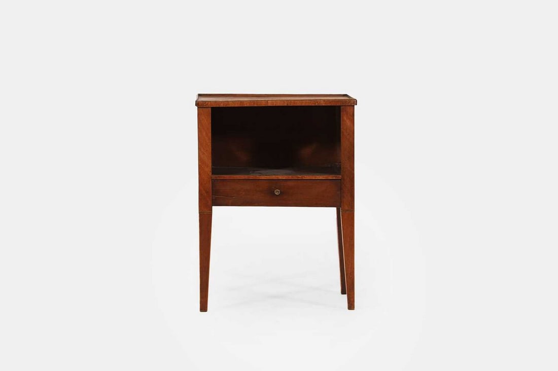 A George III mahogany night table, early 19th century,: A George III mahogany night table, early 19th century, the moulded rectangular top above an open shelf and short drawer, with pierced side carrying handles, raised on tapering square supports with str